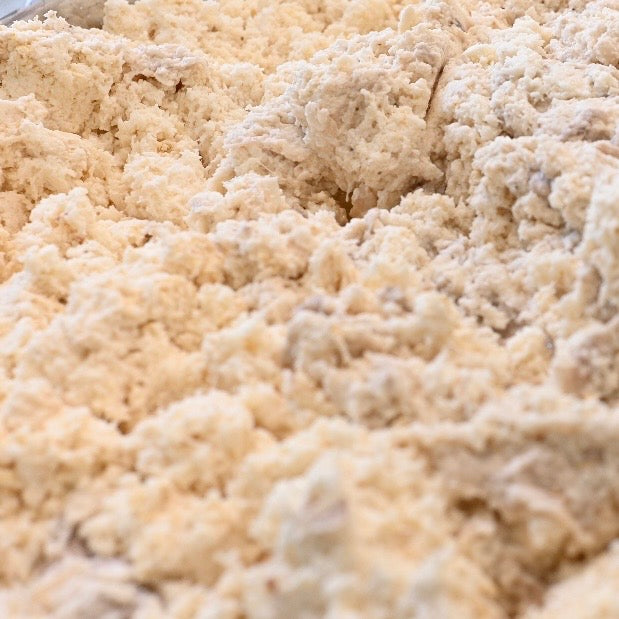 Load video: Close-up of freshly grated pasteles masa showing the authentic grated texture produced with Grandma Ann's Electric Grater.